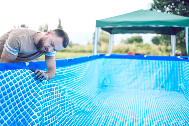 angry technician struggling to set up portable pool - above ground pool imagens e fotografias de stock