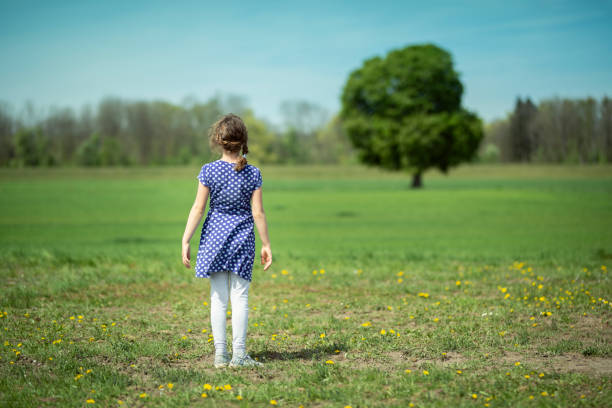 istock Little Girl looking at a tree 1145292106