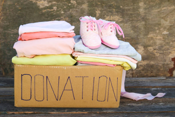 istock Donation box with clothes on the old wooden background. 1145292505