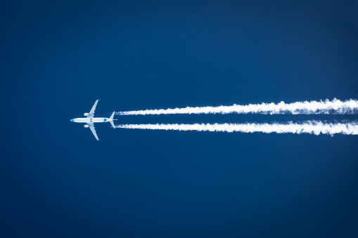 Air to Air photography of a Boeing 737 with the registration SP-ENW of the Polish airline Enter Air. Flying in blue sky and drawing a Condensation Trail, Contrail. These vapor trails are small particle out of the fuel which condensates on cloud condensation nuclei. The vertical separation is 2000 feet which is 600 meters for this photo