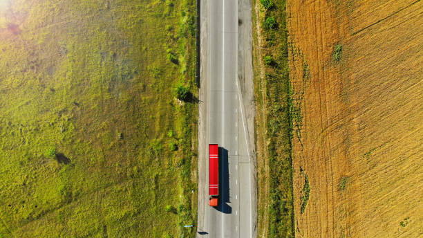 caminhão vermelho em uma estrada entre campos. vista superior. - flatbed truck truck truck driver heavy - fotografias e filmes do acervo