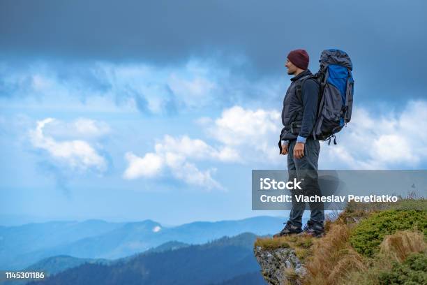 The Man With A Camping Backpack Standing On The Cliff Stock Photo - Download Image Now