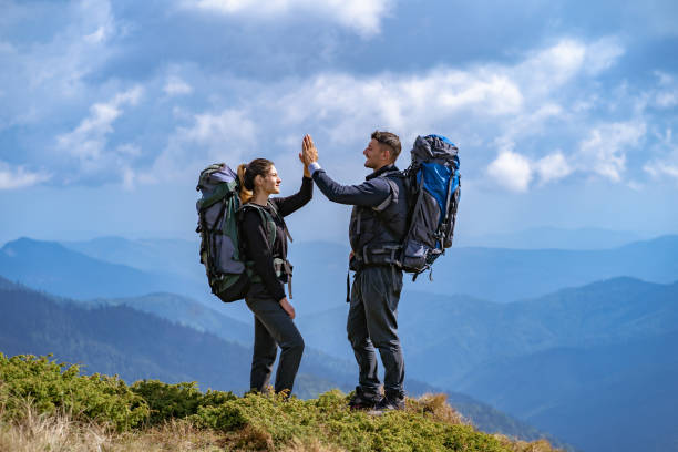 istock The happy couple with backpacks gesturing on the mountain 1145303085