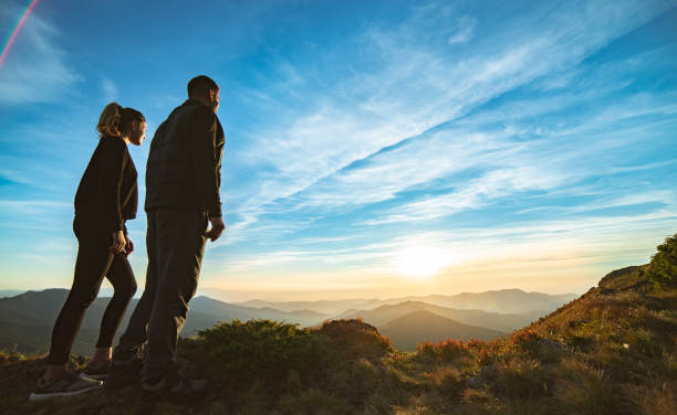 istock The couple standing on the beautiful mountain sunset background 1145303086