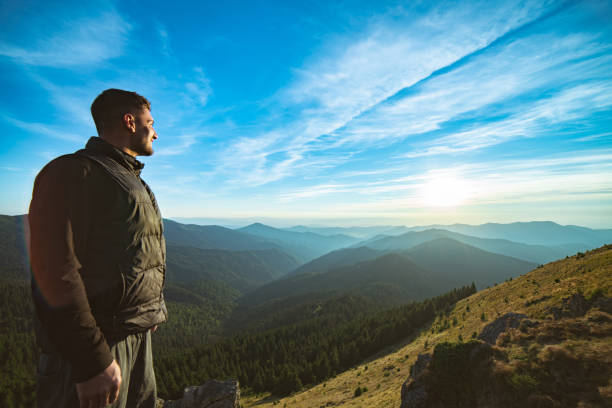 istock The smiling man standing on the beautiful mountain landscape background 1145303124