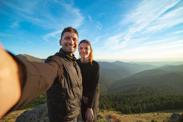 istock The smiling couple taking a selfie on the mountain background 1145303165