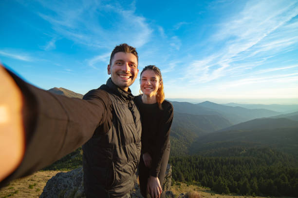 istock The smiling couple taking a selfie on the mountain background 1145303166