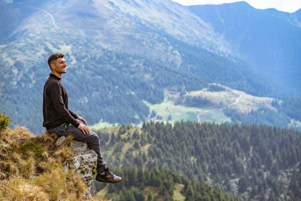 istock The happy man sitting on the cliff 1145303168