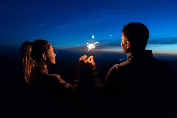 istock The happy couple holding firework sticks on the sunrise background 1145304332