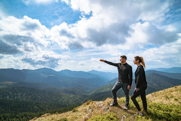 istock The couple gesturing on the mountain with a picturesque cloudscape 1145304517