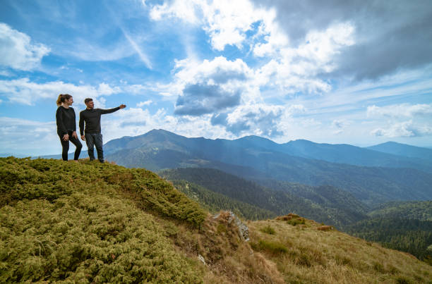 istock The couple gesturing on the mountain with a picturesque cloudscape 1145304534