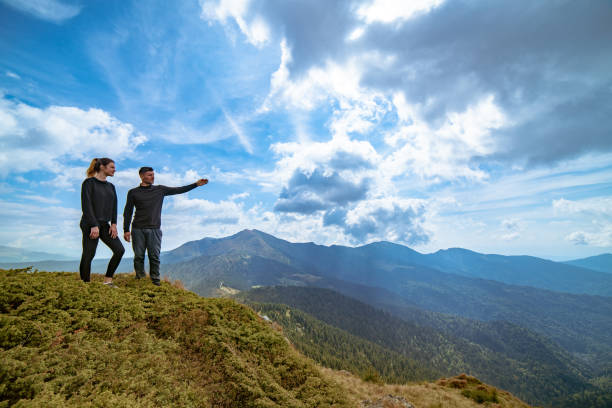 istock The couple gesturing on the mountain with a picturesque cloudscape 1145304628