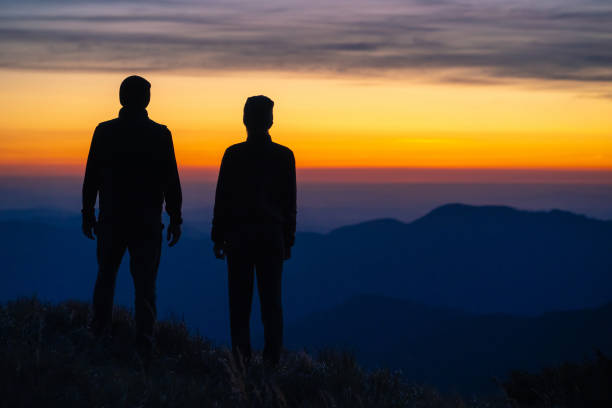 istock The couple standing on the mountain on a sunrise background 1145307034