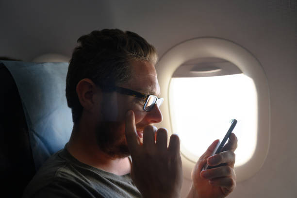 istock Airplane Passenger Uses WiFi Internet on Mobile Phone 1145308661