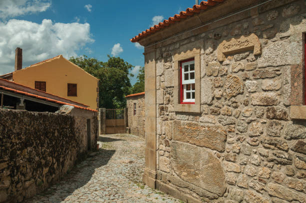 istock Old house with stone wall and small window in an alley 1145314229