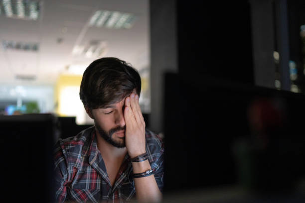 istock Tired businessman working late and rubbing eyes 1145315273