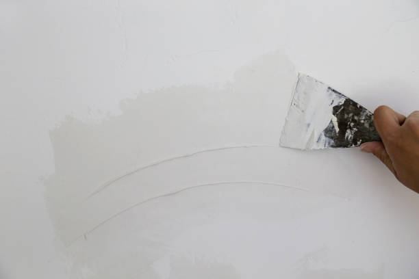 istock Man plastering wall with putty-knife, close up image. Fixing wall surface and preparation for painting. 1145315503