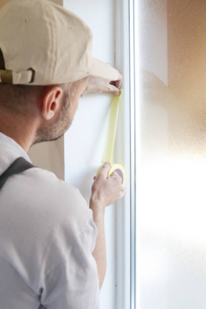 istock Man putting tape on the wall. The simple step for the quick and easy painting process. Renovation house concept. 1145315847