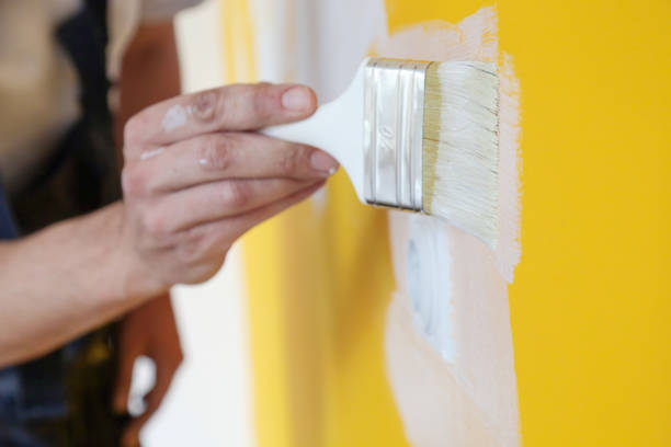 pittura con vernice bianca su una parete gialla - newly completed foto e immagini stock