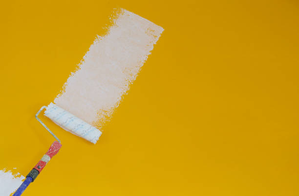 istock Painting with white paint over a yellow wall 1145316711