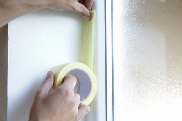 istock Man putting tape on the wall. The simple step for the quick and easy painting process. Renovation house concept. 1145316919