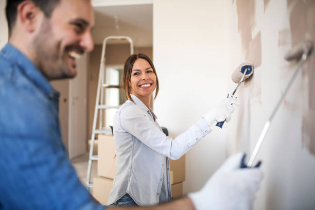 istock Beautiful woman painting wall with roller. 1145316939