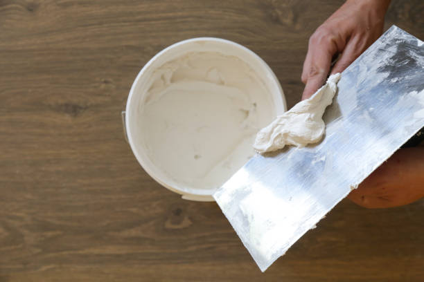 istock Man plastering wall with putty-knife, close up image. Fixing wall surface and preparation for painting. 1145319093