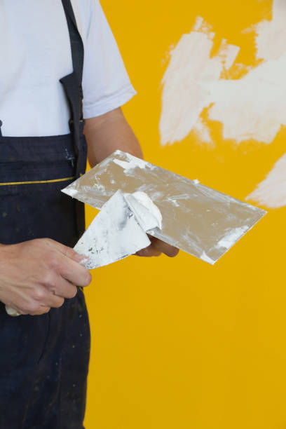 istock Man plastering wall with putty-knife, close up image. Fixing wall surface and preparation for painting. 1145319232
