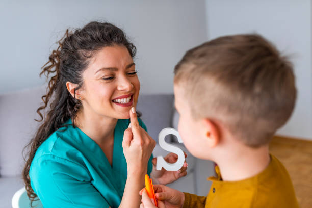 niedlicher kleiner junge im büro der sprachtherapeuten - child speech therapy adult stock-fotos und bilder