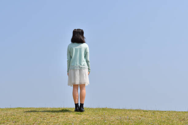 istock Japanese girl standing in the blue sky(Rear view) 1145330099