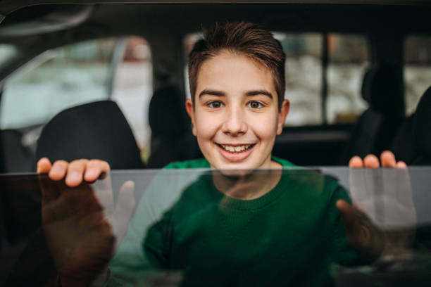 istock Smiled kid looking through window of car 1145330238
