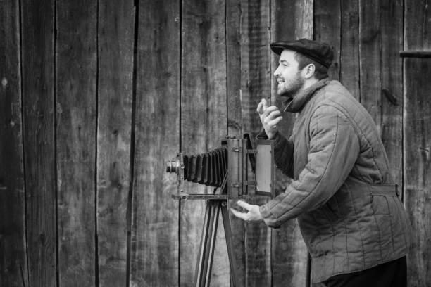 istock Old fashioned photographer asks for a smile. Works on large format camera. Idea - photography of the 1930s-1950s 1145330247