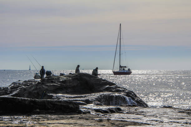 2013.01.06, Kamakura, Japan. Auto trip around famous places of Japan.fishermen on the rocks of Enoshima.