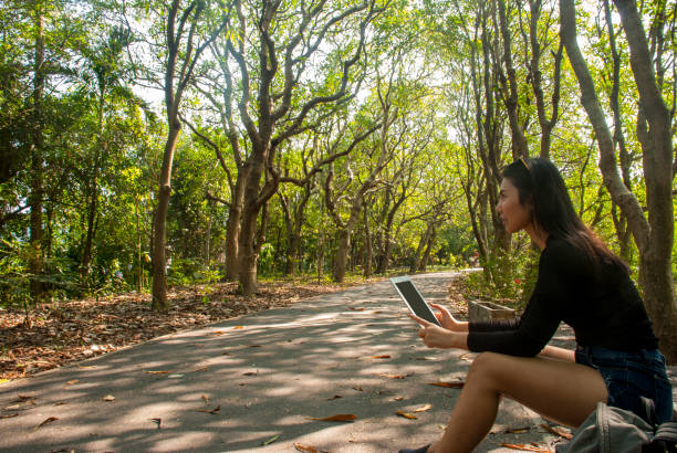 istock Asian women sit in the park. 1145351684