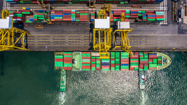 istock Container ship loading and unloading in deep sea port, Aerial top view of logistic import export transportation business by container ship in open sea. 1145365413