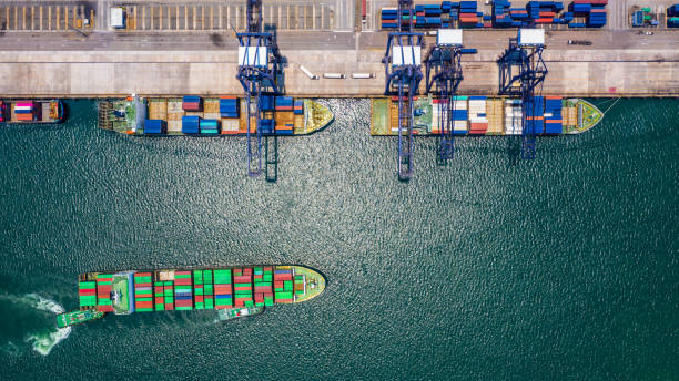 istock Container ship loading and unloading in deep sea port, Aerial top view of logistic import export transportation business by container ship in open sea. 1145365479