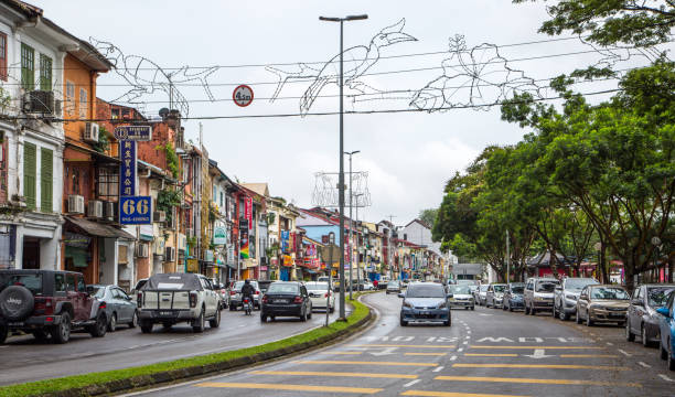 Malaysia: Kuching Traffic moves along Jalan Main Bazaar on the waterfront in Kuching. kuching waterfront stock pictures, royalty-free photos & images