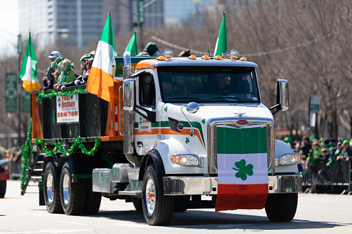 Chicago, Illinois, USA - March 16, 2019: St. Patrick's Day Parade, Large truck Peterbilt with Irish flags going down columbus dr.