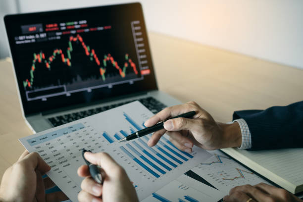 istock Two investors are working together with analyzing the stock data graphs in the paper and viewing the data on the laptop screen. 1145371390