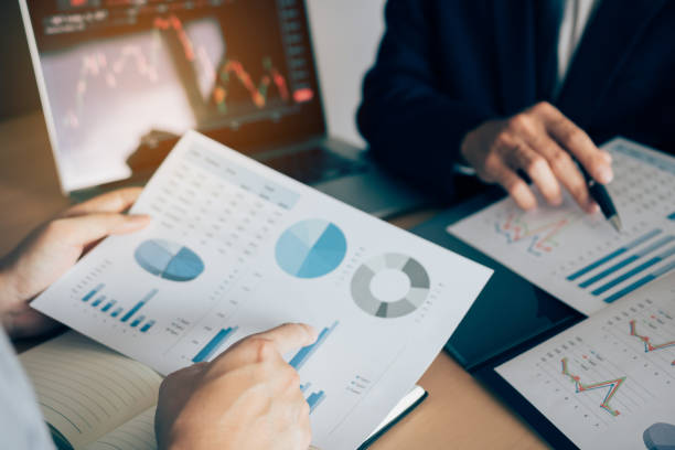 istock Two investors are working together with analyzing the stock data graphs in the paper and viewing the data on the laptop screen. 1145371467