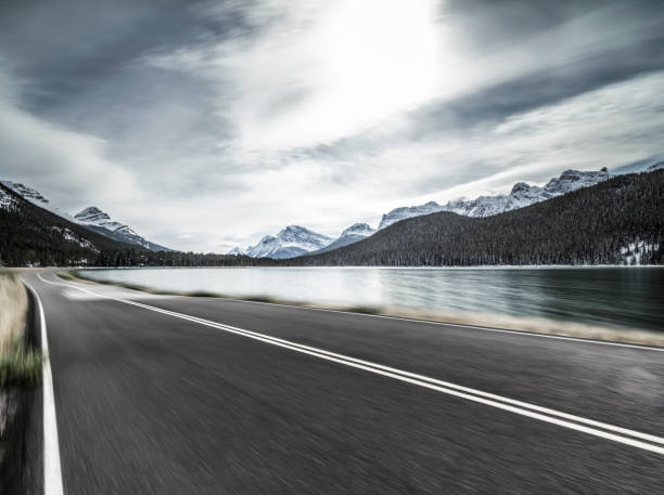 istock road by lake against rocky mountains 1145382646