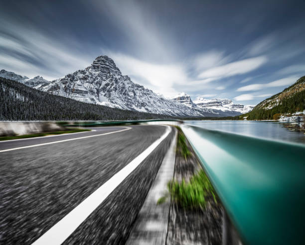 istock road by lake against rocky mountains 1145382650