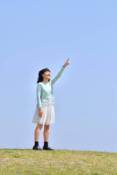 istock Japanese girl pointing at the blue sky 1145382903