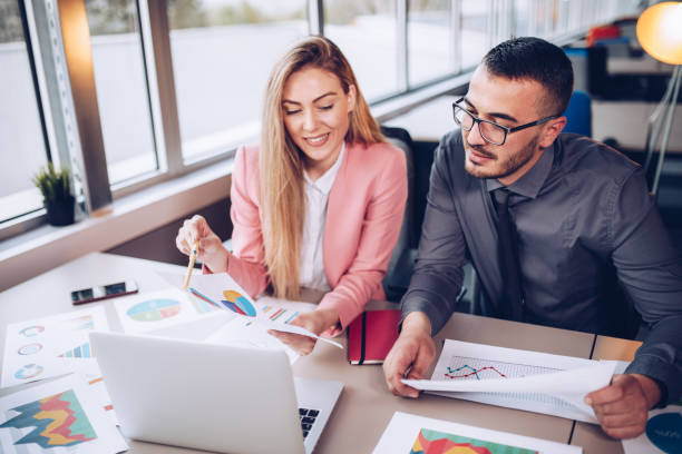 istock Young couple working together in business office. 1145390667