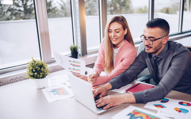 istock Young couple working together in business office. 1145390701