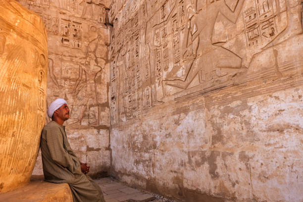 homem egípcio que descansa no templo antigo, egipto - temple of luxor hypostyle hall - fotografias e filmes do acervo