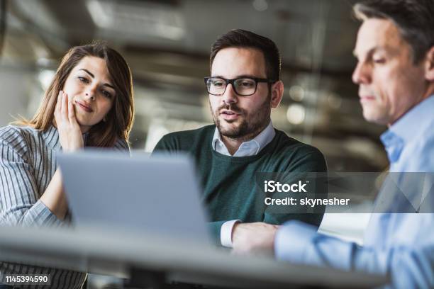 Junges Ehepaar Und Immobilienmakler Mit Laptop Auf Einem Treffen Im Büro Stockfoto und mehr Bilder von Rat