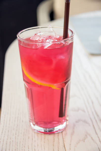 istock Iced rose and berries tea with lemon sliced on light brown table. Cold mocktail. 1145394710