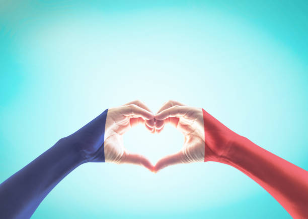 istock France national flag pattern on people's hands in heart shape on blue mint sky (isolated with clipping path) 1145395546