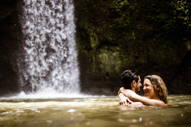 istock Happy embraced couple talking in water at rainforest. 1145399210
